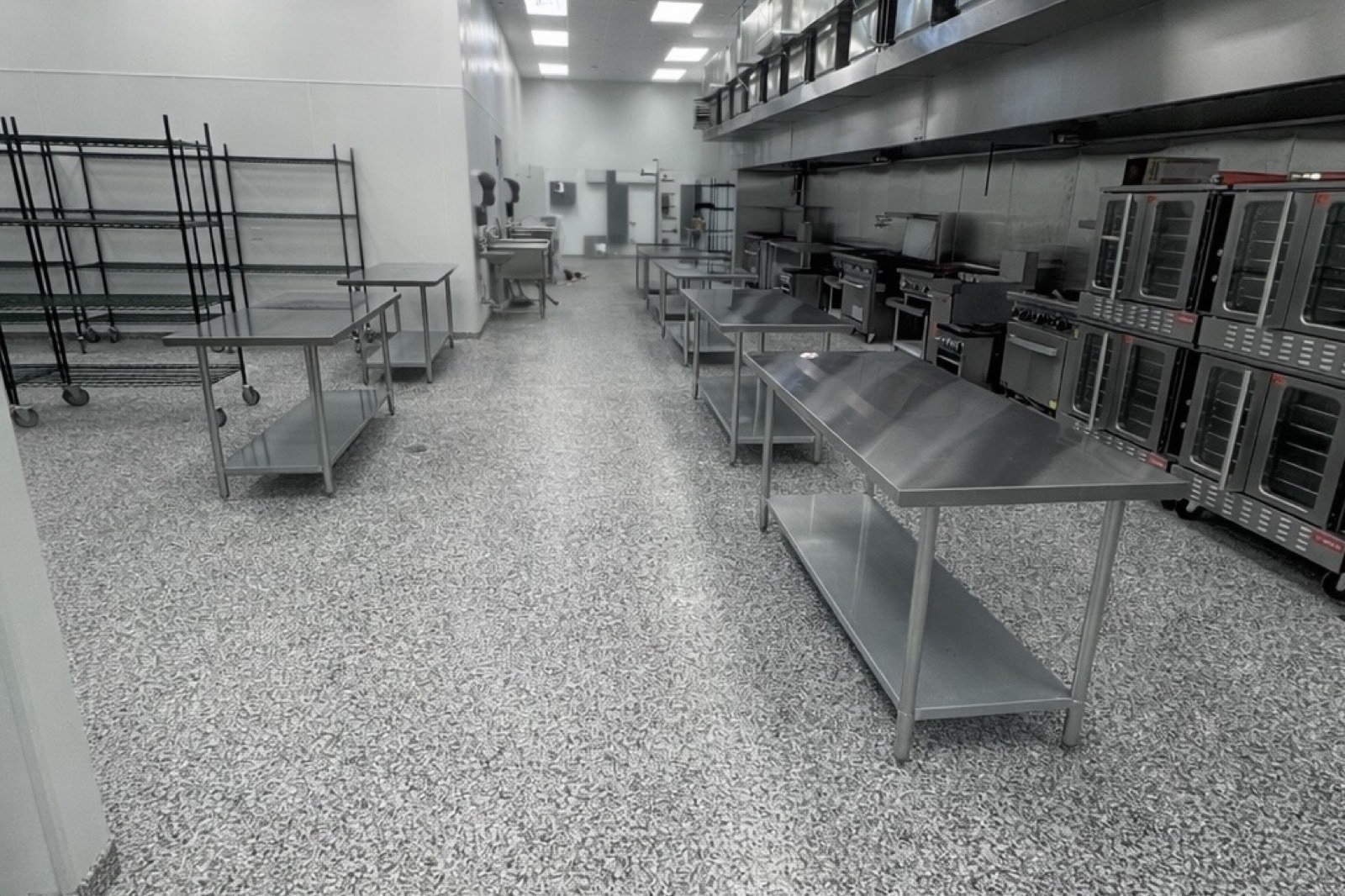 Wide view of PurePrep Langford kitchen showing prep tables, ovens, and commercial cookline